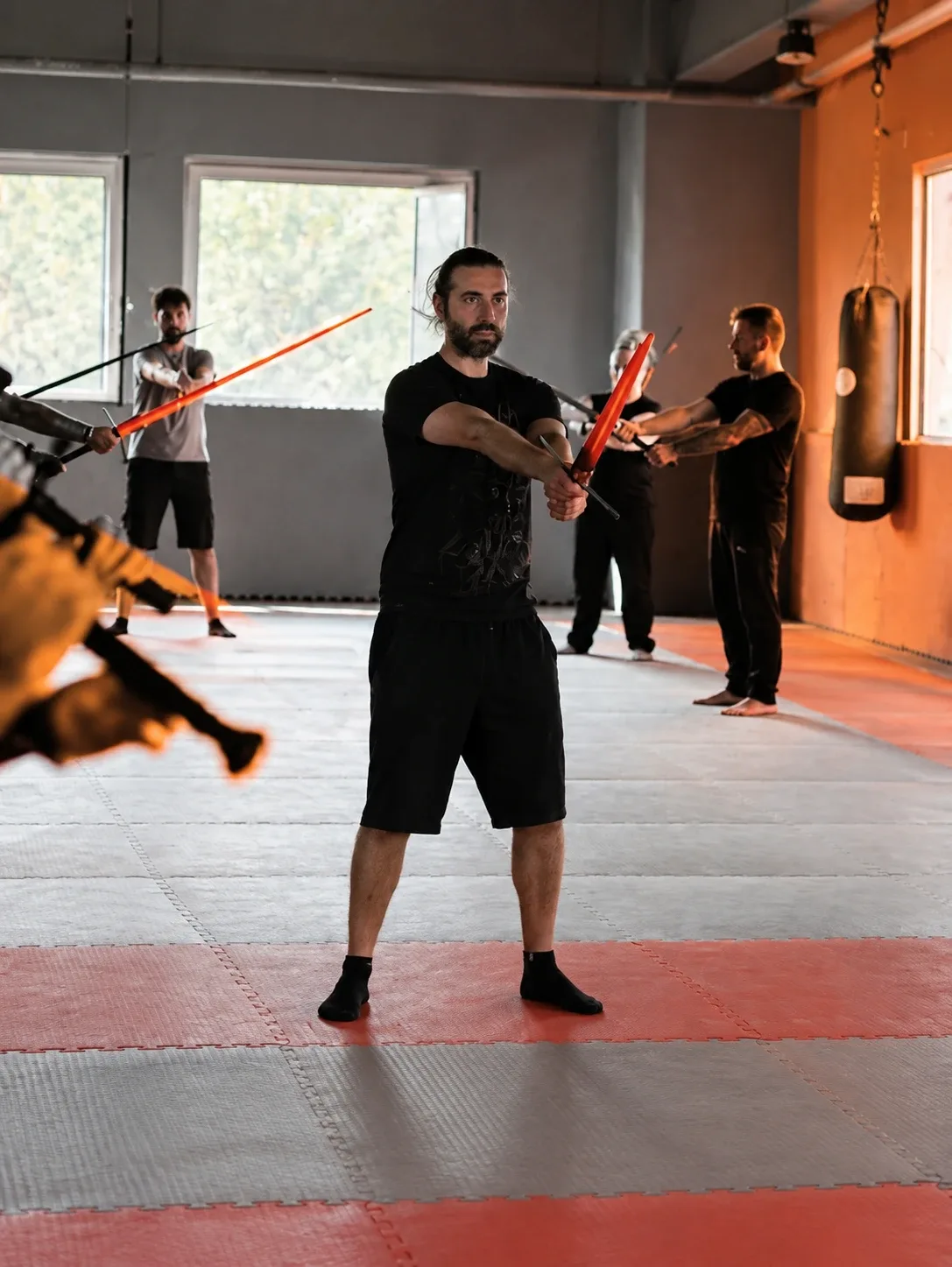 Allievi di Scherma Storica in guardia con le spade durante una lezione nel dojo